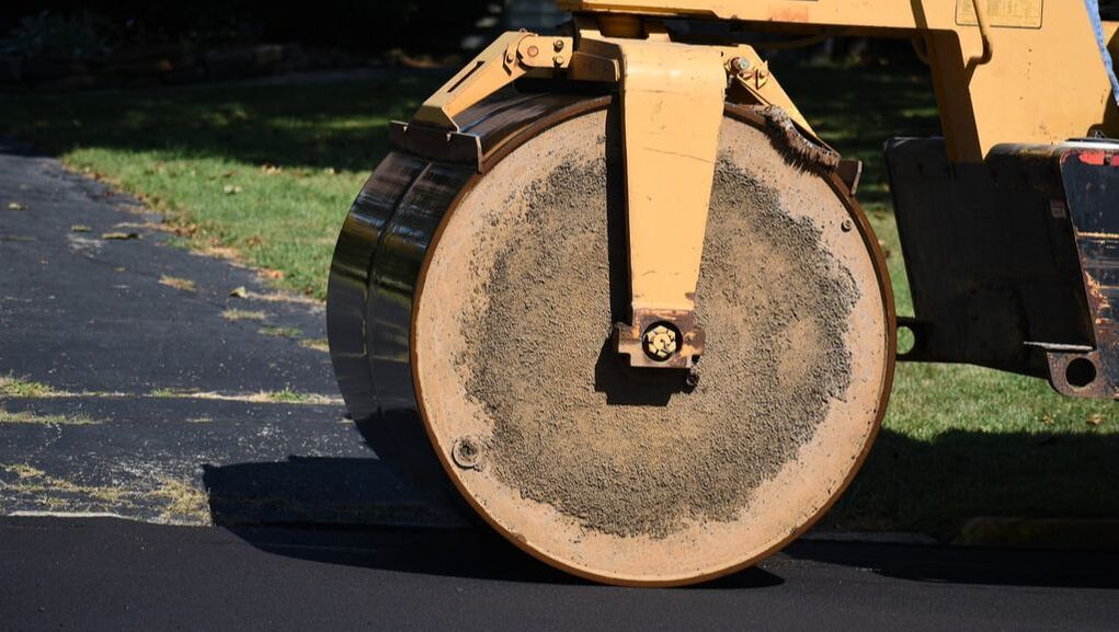 Powered equipment smoothing out asphalt pavement